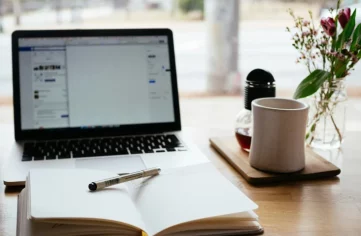 Desk with computer, book and cup - Coaching in Greenwich