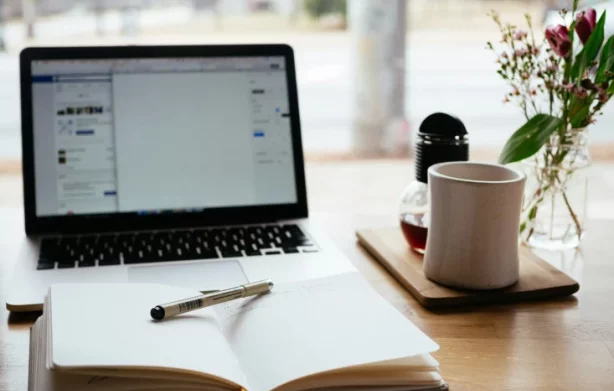 Desk with computer, book and cup - Coaching in Greenwich